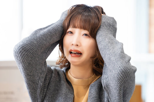 頭を抱えてショックを受けている女性