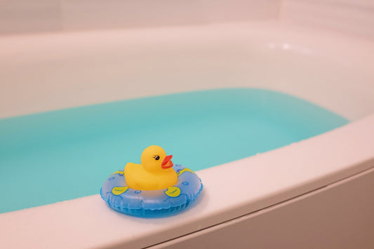 浮き輪をつけたアヒルが浴槽の縁にいる